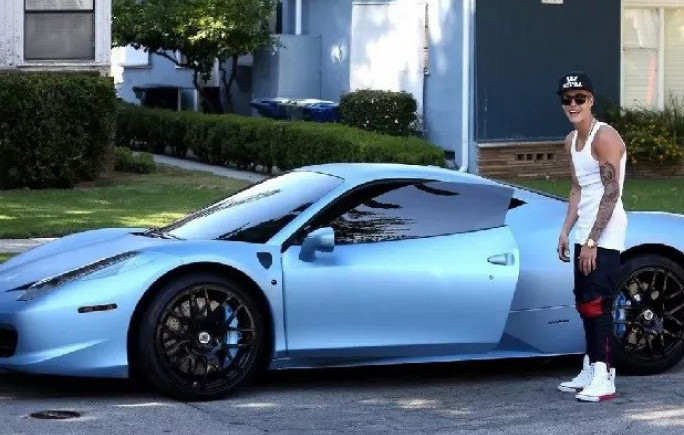 Justin Bieber posa ao lado do Italia 458, carro da Ferrari que ele pintou de azule depois leiloou 